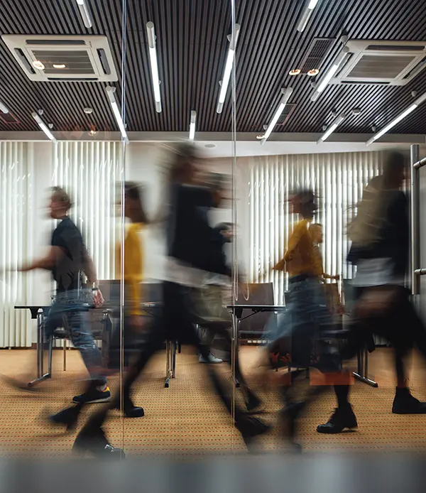 Geschäftsleute gehen durch einen modernen Open Space. Bewegungsunschärfe